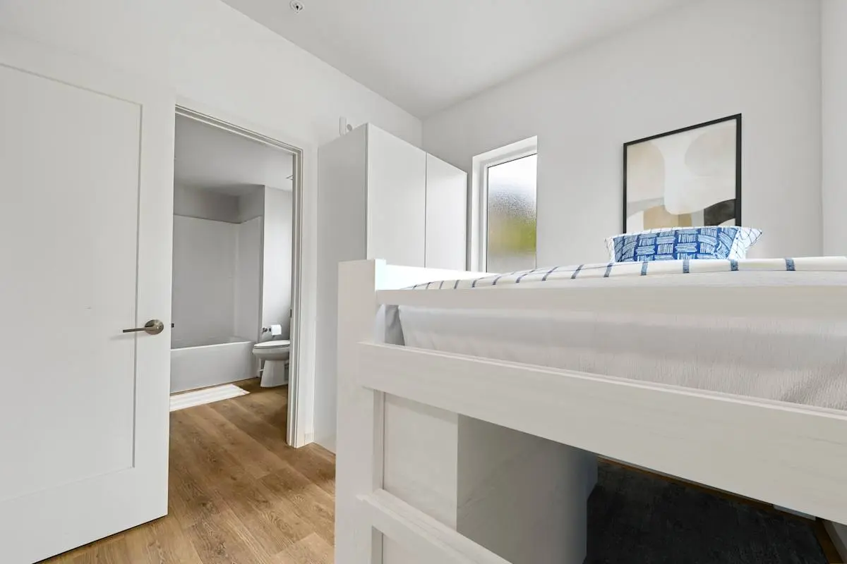 Bedroom with bed and mirror toward the bathroom