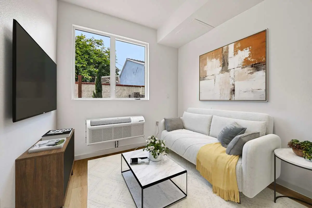 Living room with sofa, coffee table, TV, and artwork