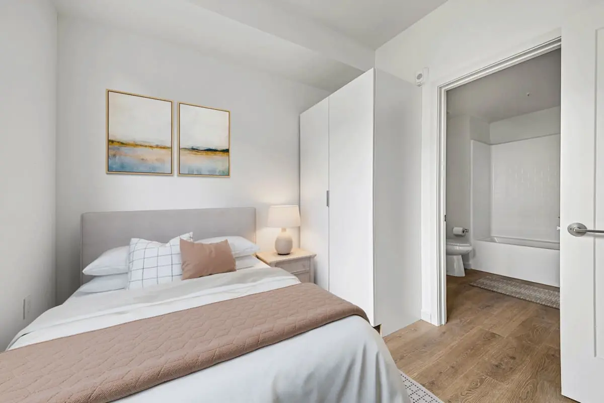 Bedroom with nightstand, lamp, and artwork