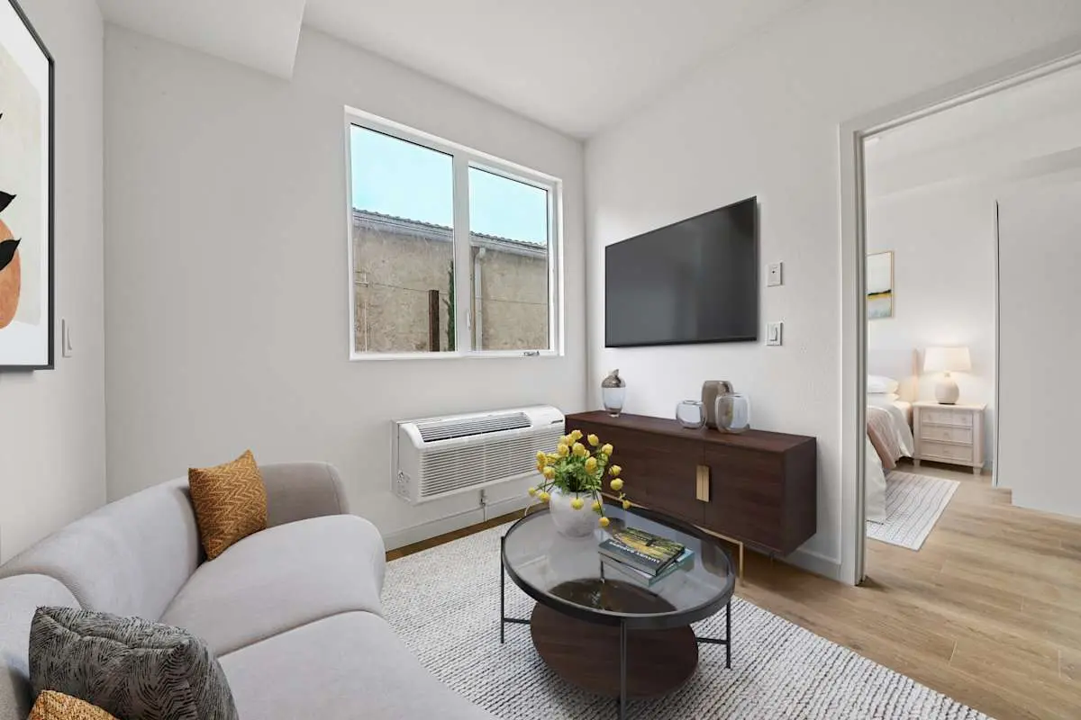 Living room with sofa, coffee table, and wall-mounted TV